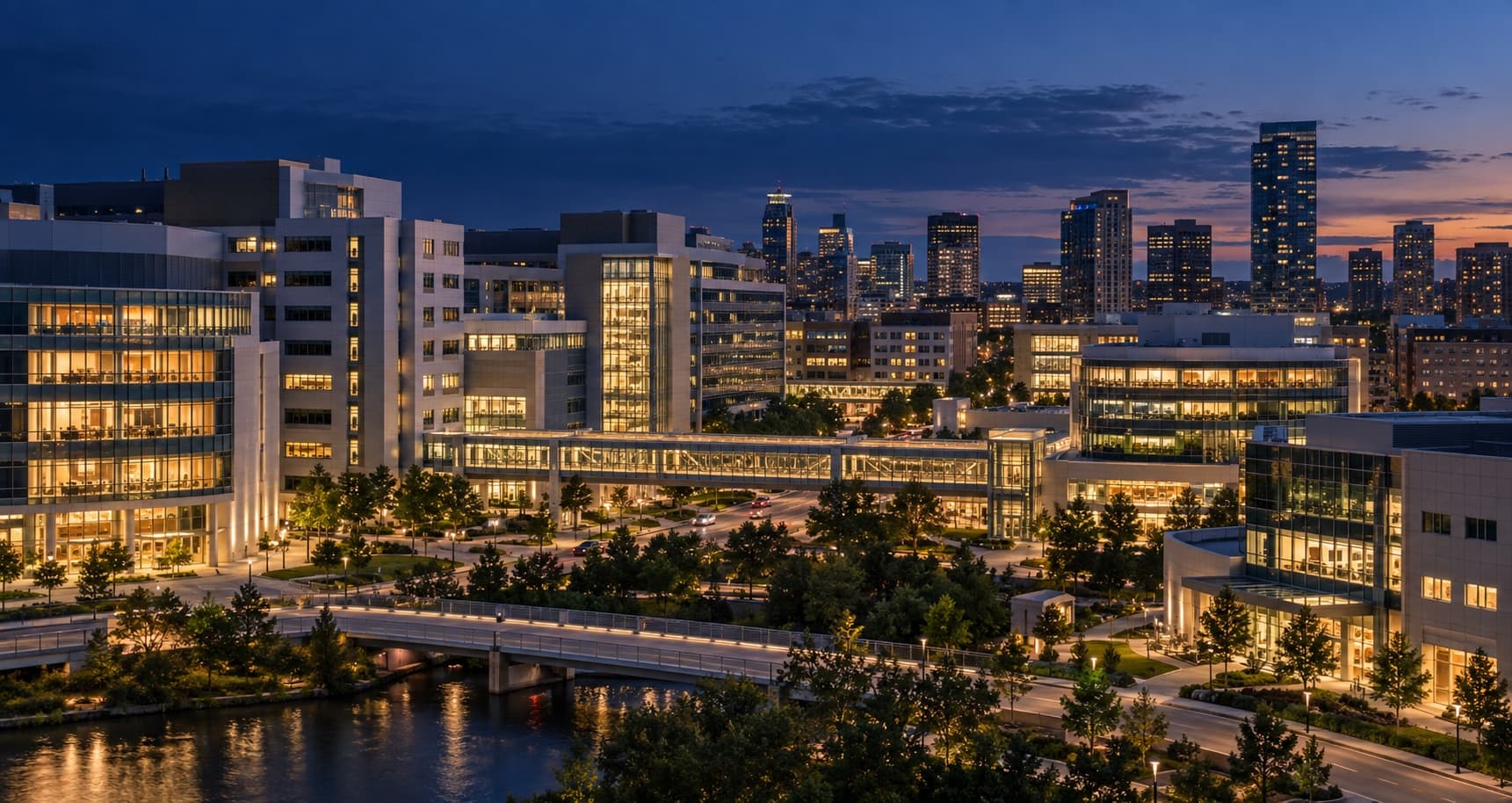 A connected healthcare district and city skyline at twilight.